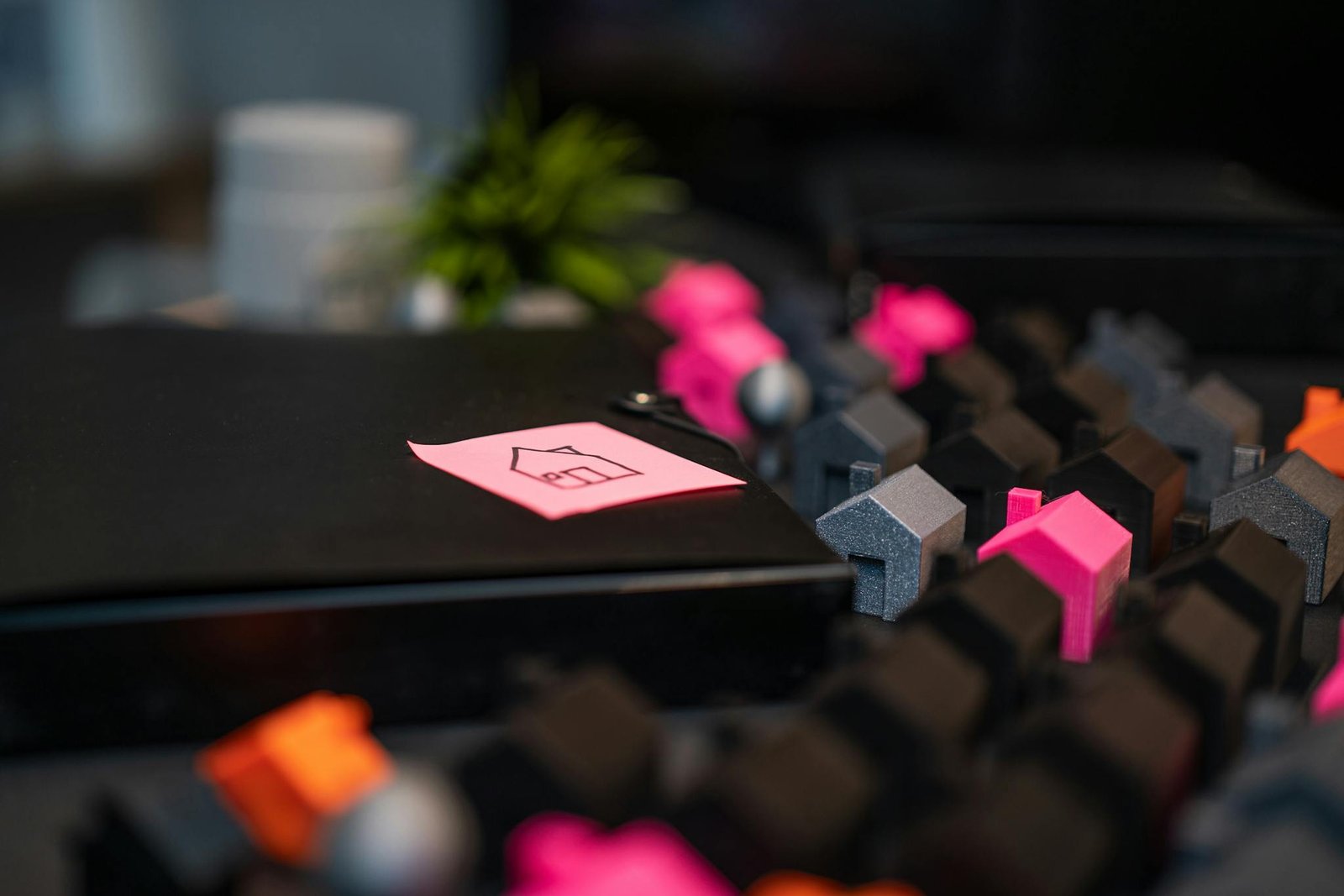 Close-up of model houses and a house sketch on a sticky note, symbolizing real estate concepts.